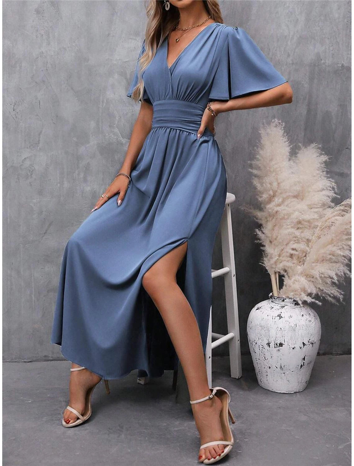Detailed view of the V-neckline and short sleeves of the elegant maxi dress.