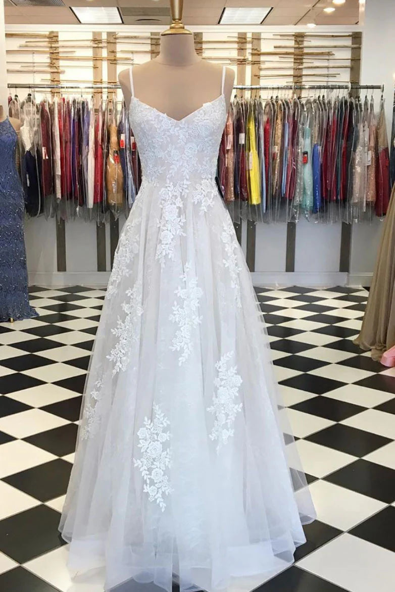 Woman wearing an elegant light champagne long tulle lace A-line V-neck prom dress.