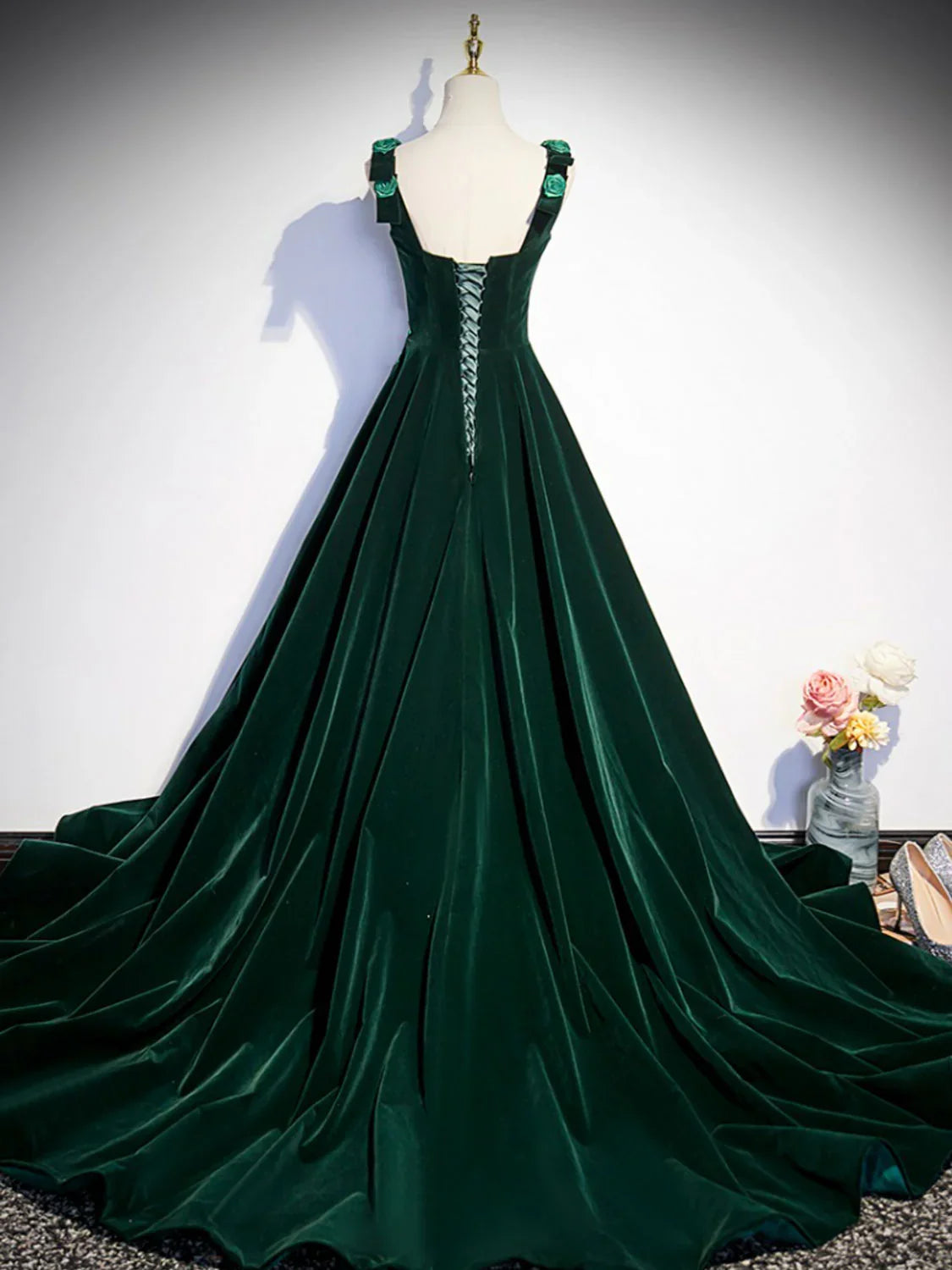 Close-up back view of the green velvet dress, showcasing the intricate lace-up detail.