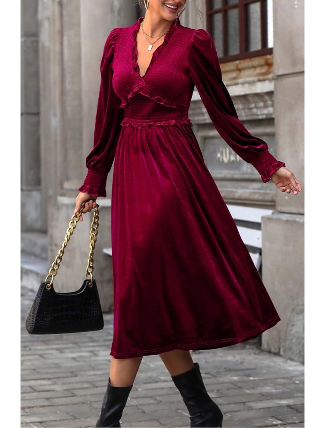 Woman wearing a burgundy velvet long sleeve V-neck maxi dress, front view.