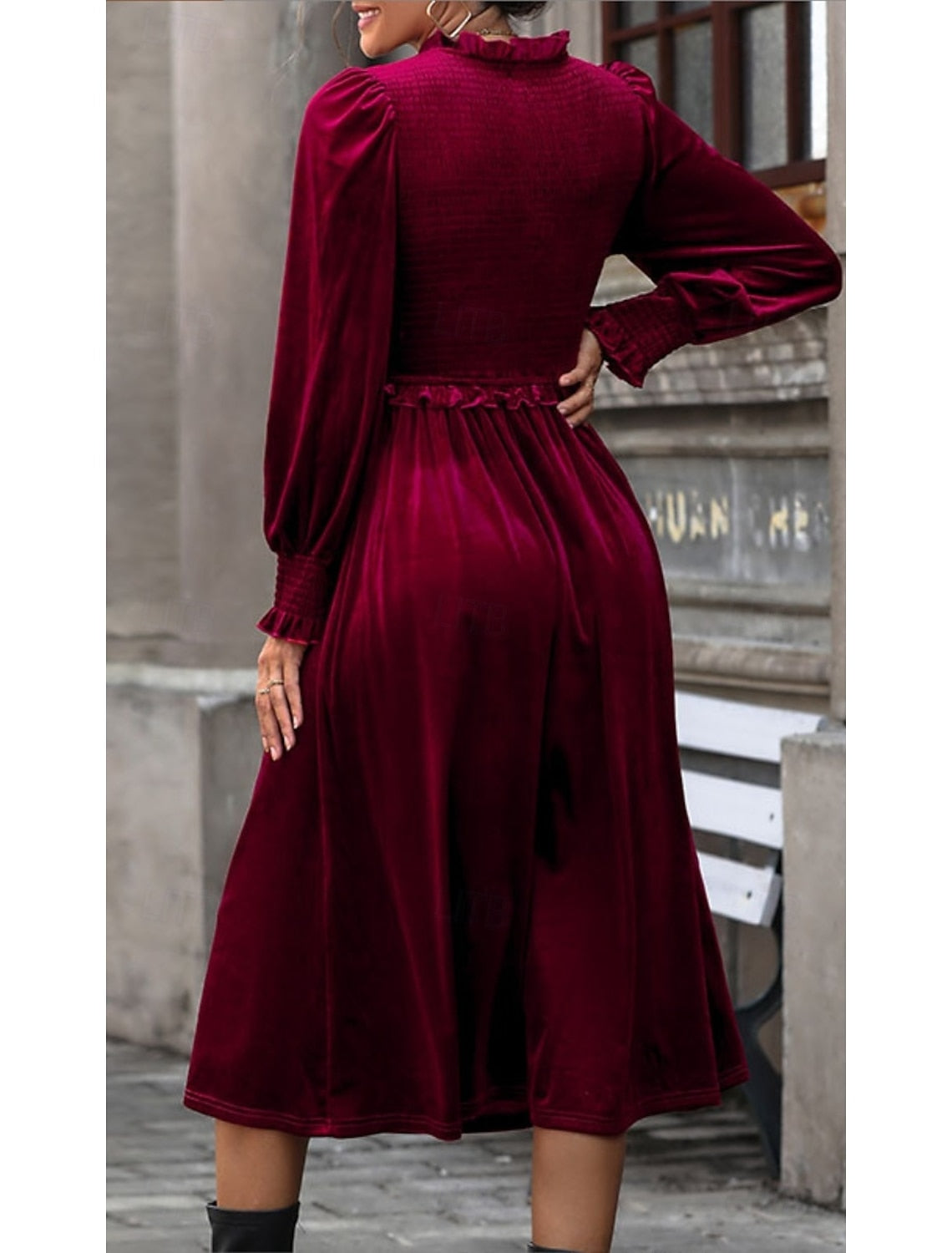 Woman in a burgundy velvet maxi dress, side view, highlighting the elastic waist.