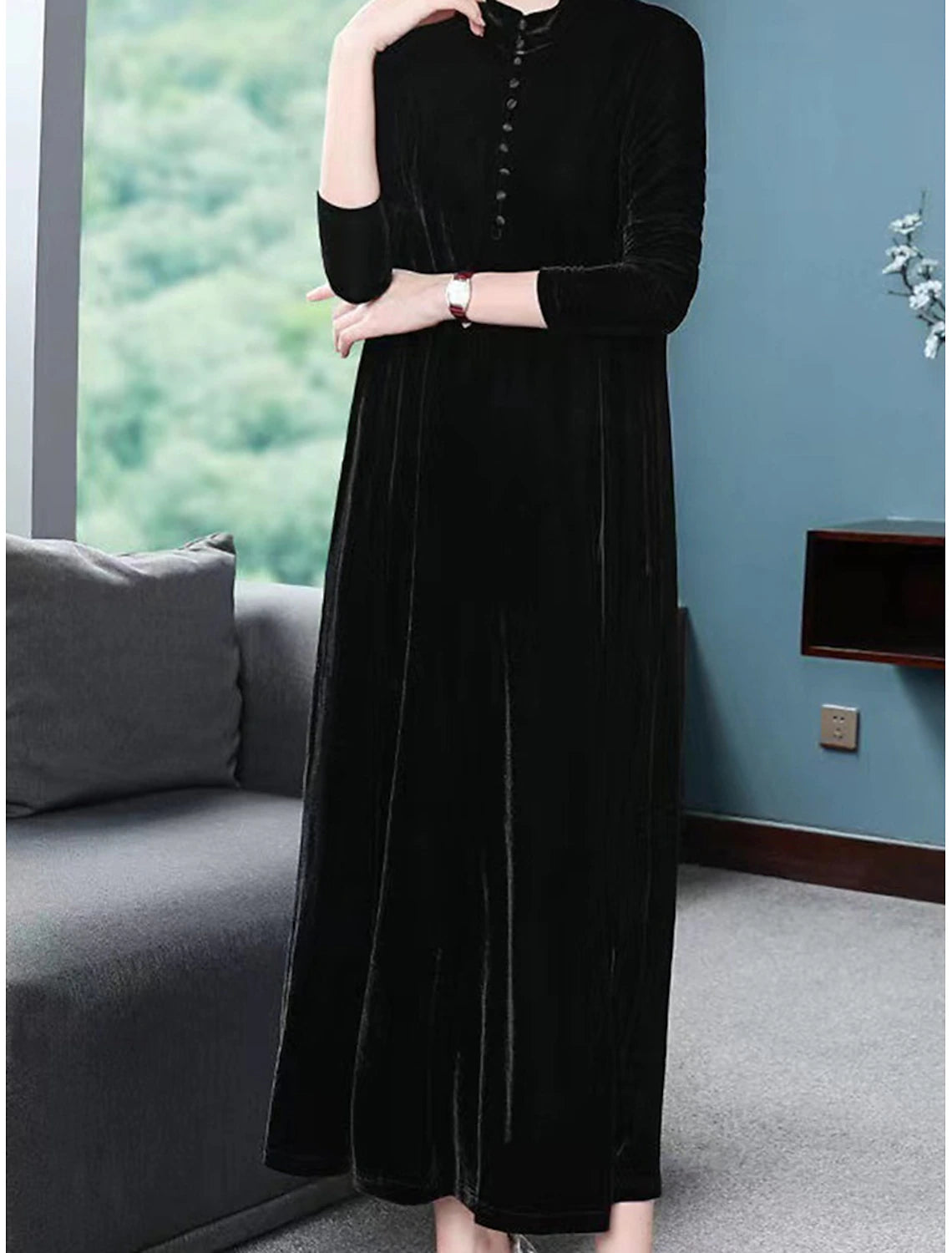 Close-up of the black velvet dress, highlighting the crew neck and decorative button details.