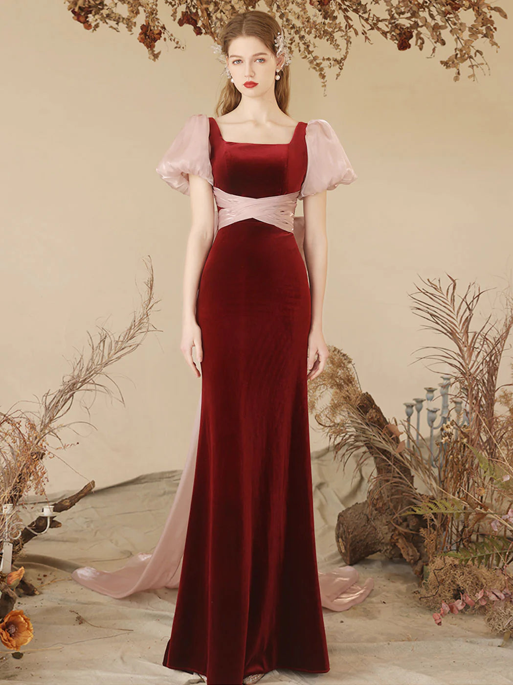 Model wearing an elegant burgundy velvet mermaid long prom dress.