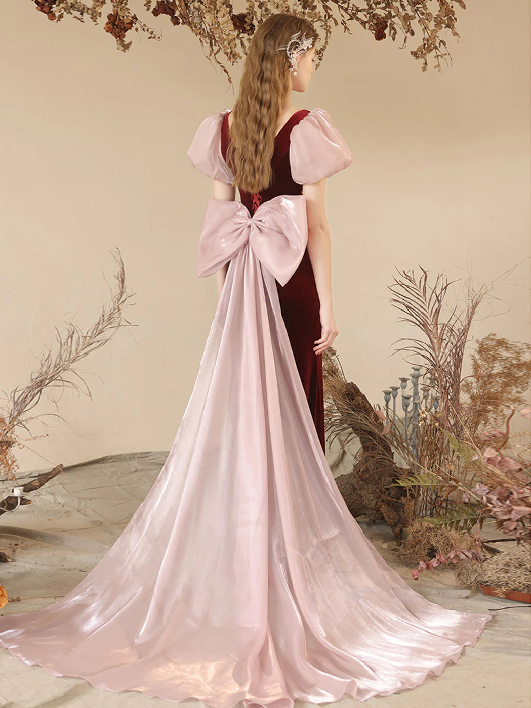 Side view of a model in a sophisticated burgundy velvet mermaid formal gown.