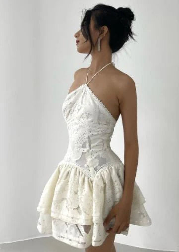 Woman wearing a short, sleeveless, vintage A-line lace homecoming dress.
