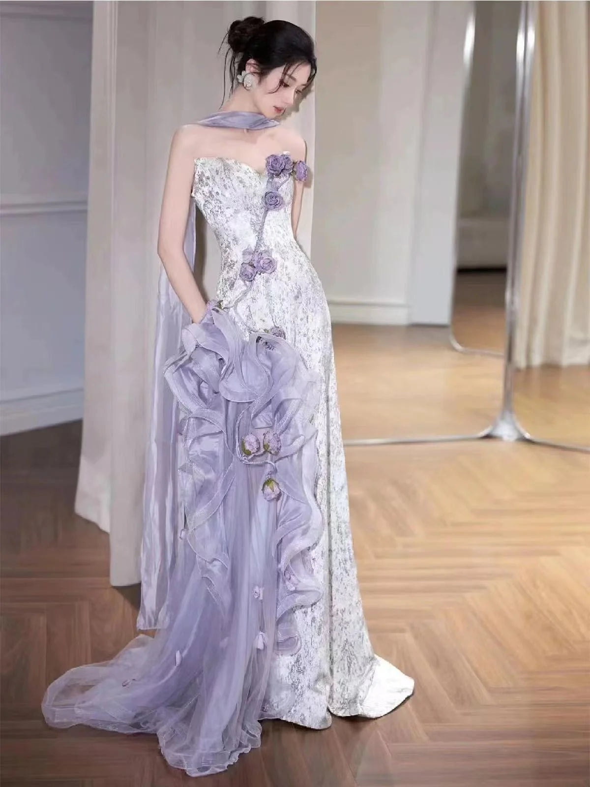 Close-up of the bodice and flowing skirt of a lilac strapless formal gown.