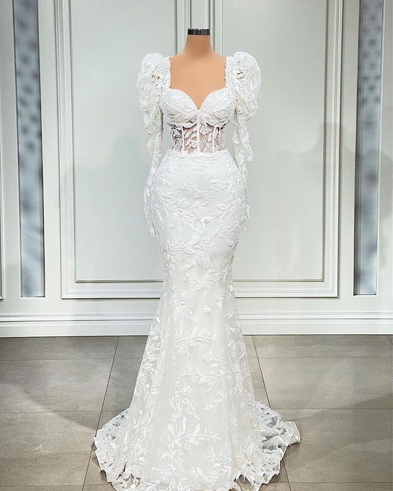 Woman wearing an elegant white mermaid long sleeve wedding dress.