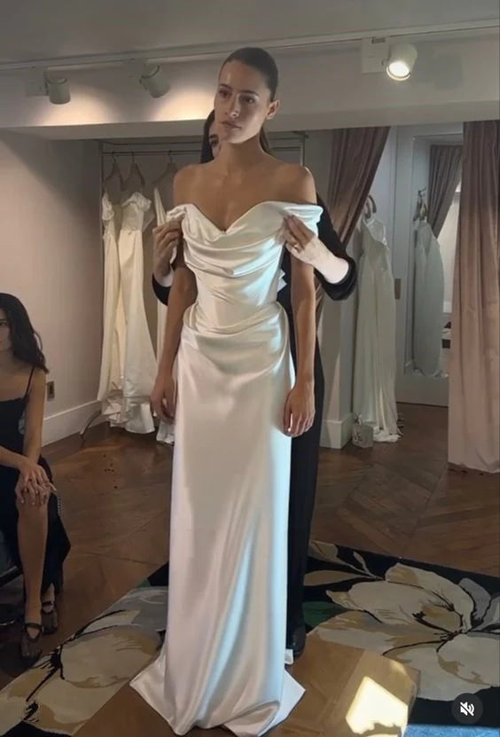 Elegant white sheath off-shoulder satin long wedding dress on a model.