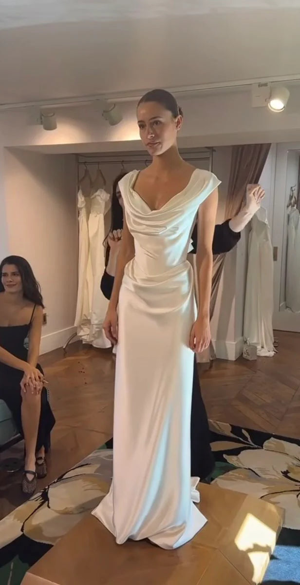 Close-up back view of a white sheath off-shoulder satin wedding dress, highlighting fabric detail.