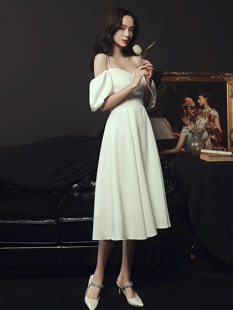 Side view of a model in a white spaghetti strap bridesmaid dress.