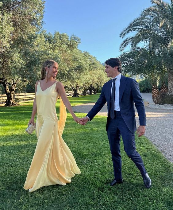 Model wearing a yellow satin A-line V-neck spaghetti strap floor length prom dress.
