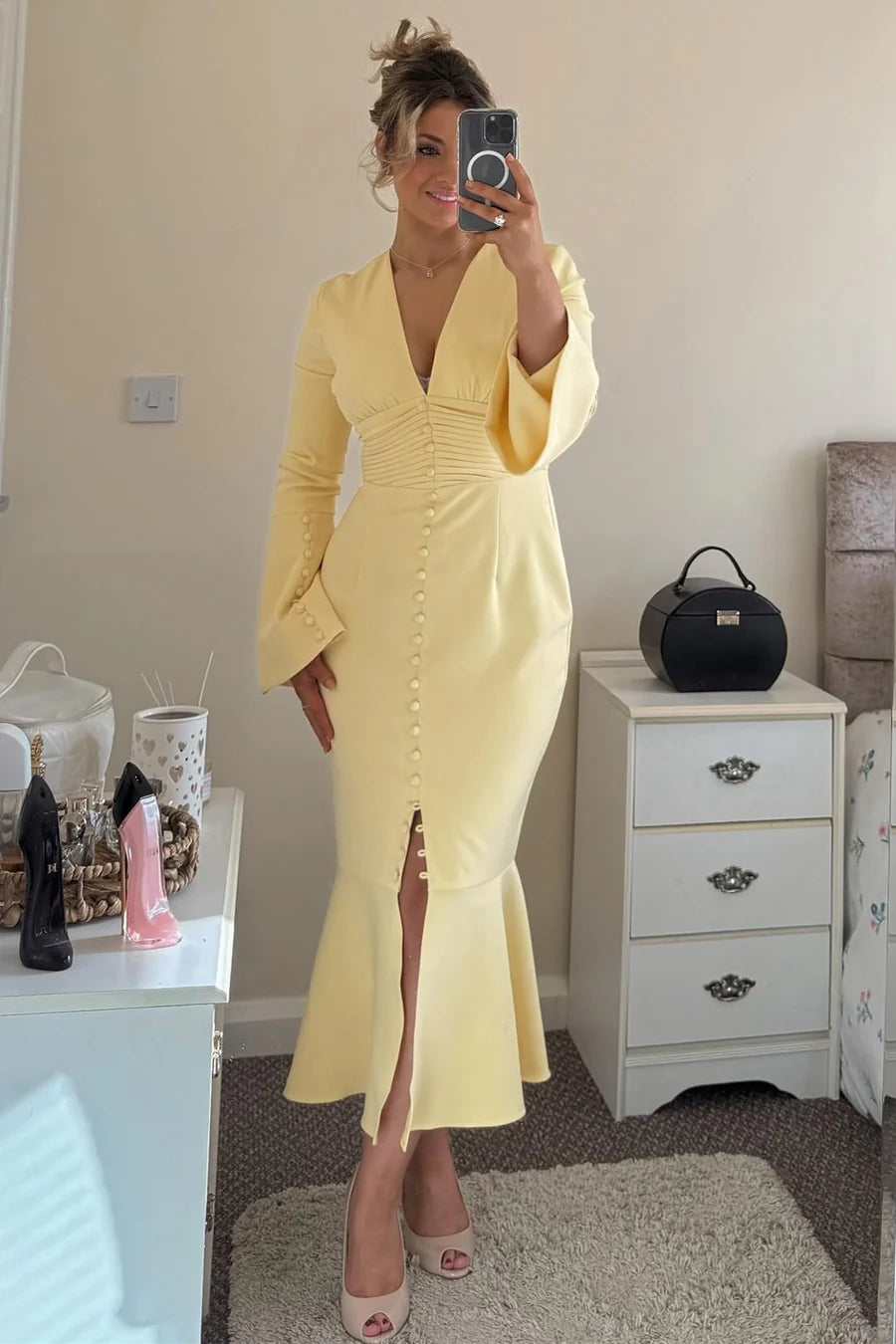 Side view of the elegant yellow mermaid dress, showcasing the flowing bell sleeves and fitted silhouette.