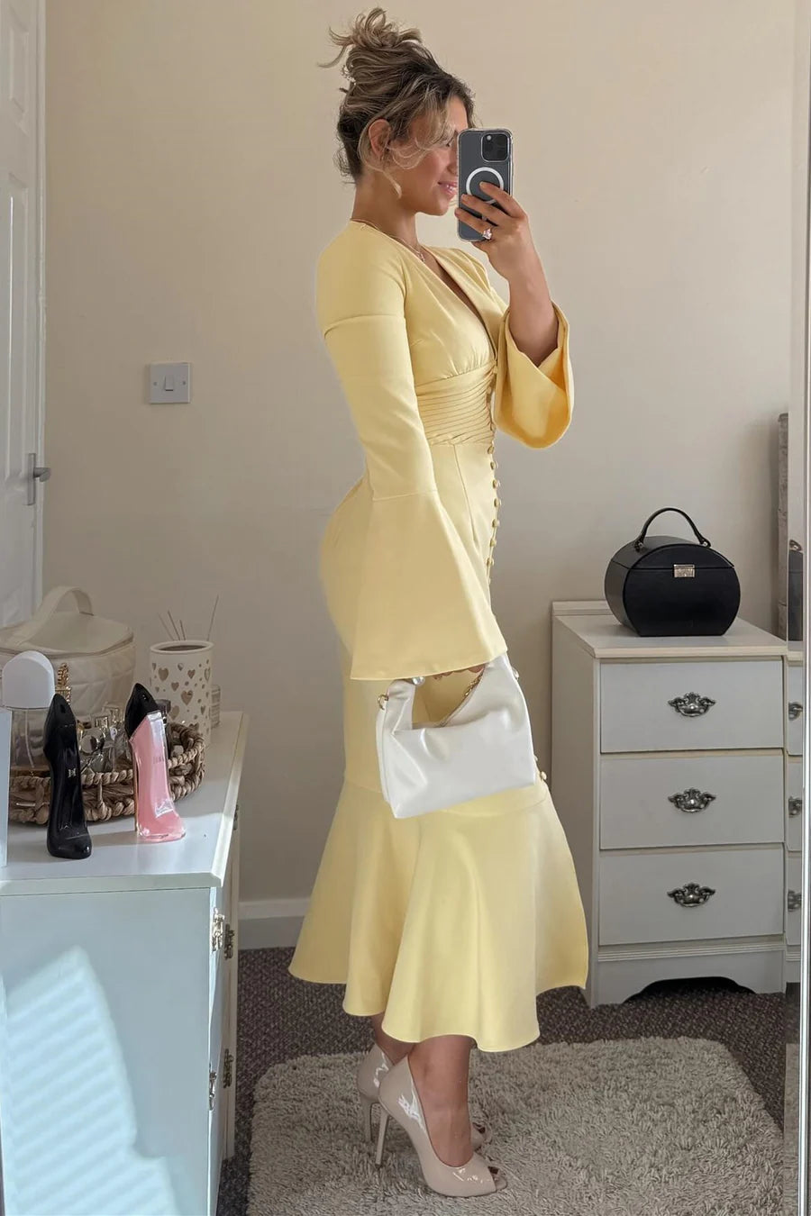 Close-up of the yellow V-neck button-up dress, highlighting the fabric texture and mermaid skirt detail.