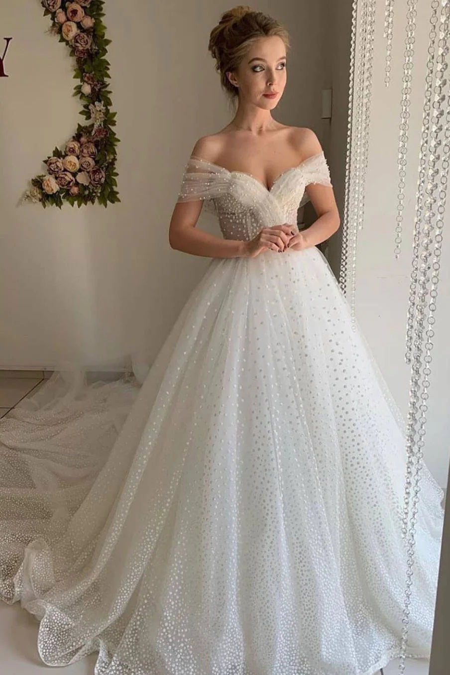 Woman in a white A-line sweetheart tulle long prom dress with a cinched waist.