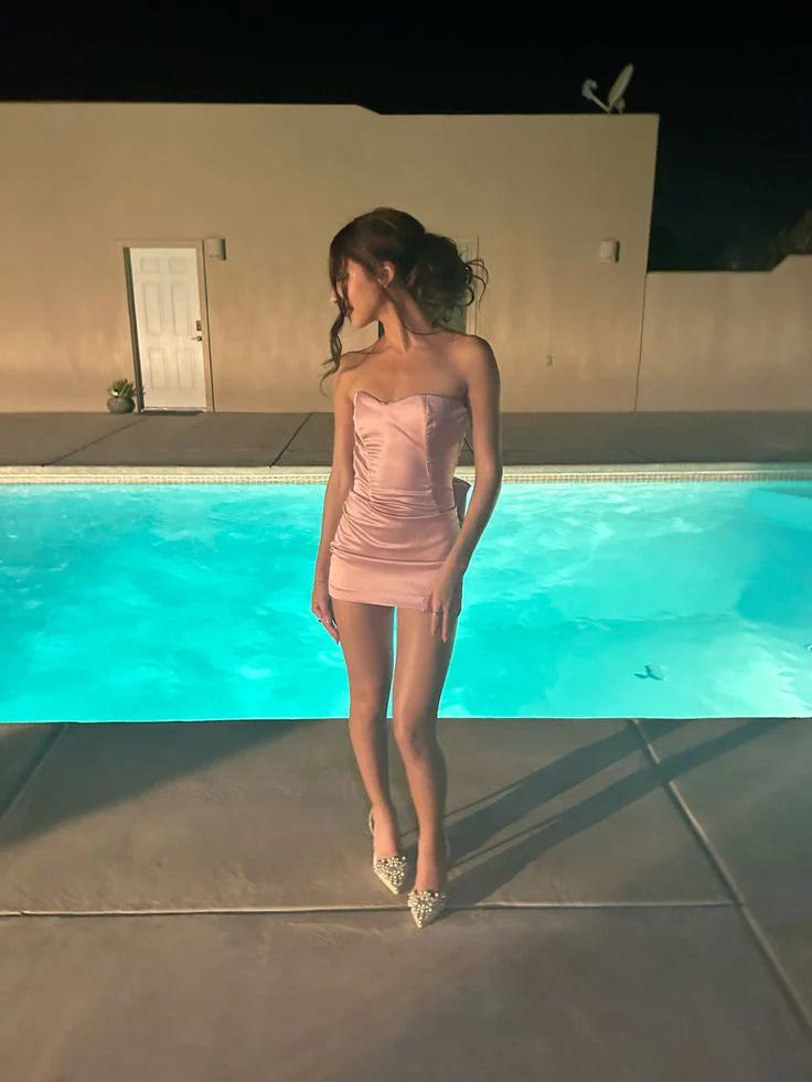 Blush pink satin bodycon mini dress with strapless sweetheart neckline and ruched bodice.