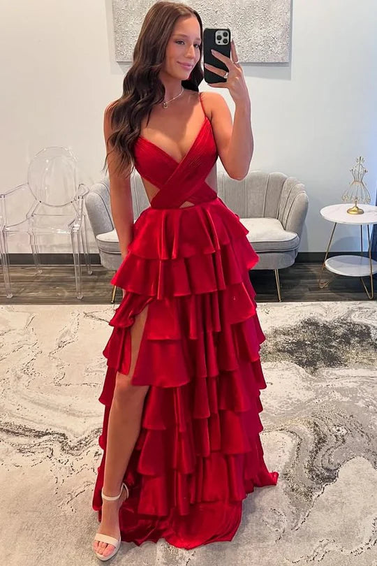 Woman posing in a glamorous V-neck spaghetti strap layered satin prom dress with a high slit.