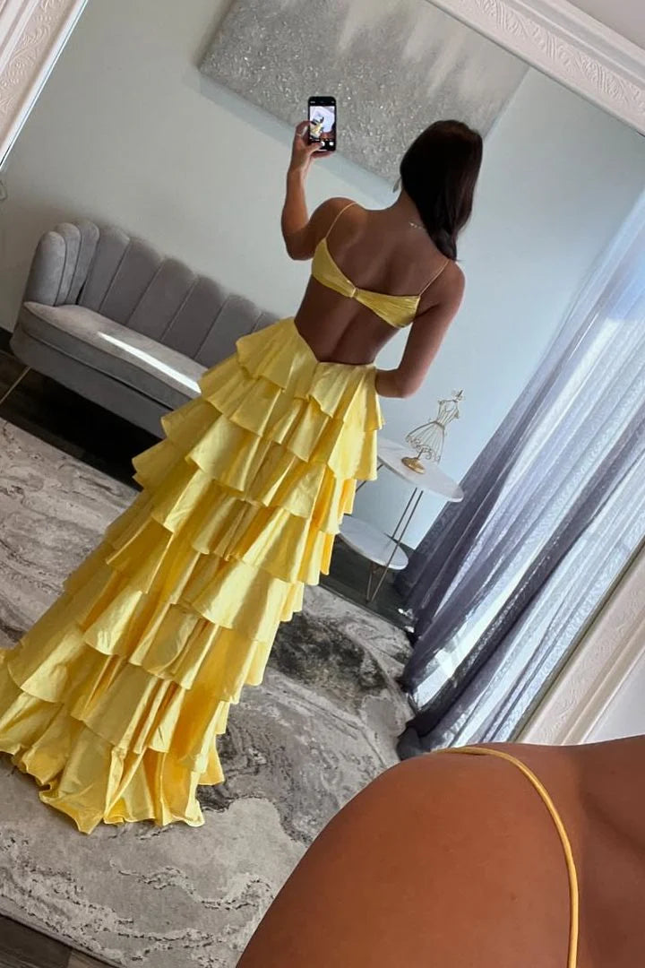 Woman in a layered satin prom dress, highlighting the V-neckline and delicate spaghetti straps.