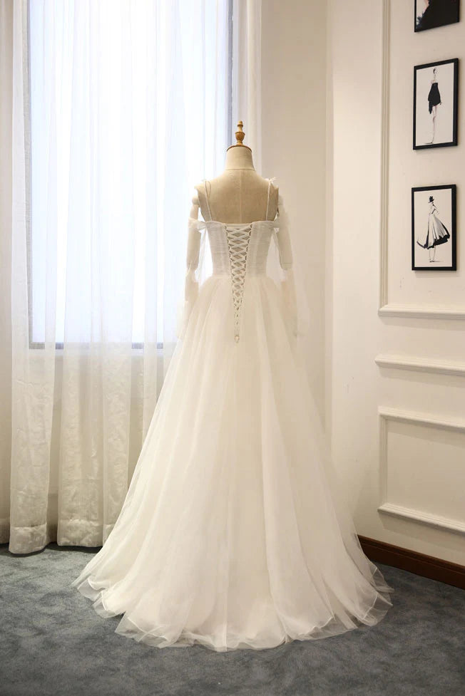 Model posing in a graceful white off-shoulder long tulle evening gown.