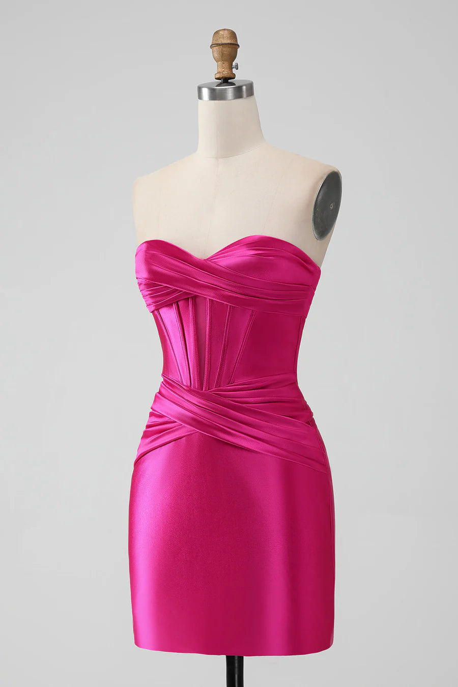 Model in hot pink strapless keyhole mini dress, side view, showing ruching detail.
