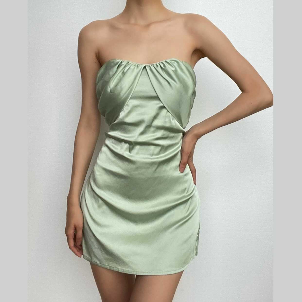 Model wearing a sage green strapless ruched A-line mini homecoming dress with a short slit.