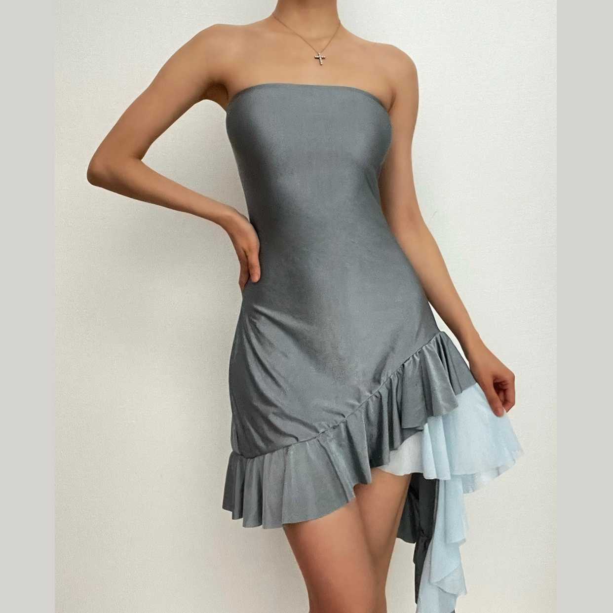 Model wearing shimmering grey strapless mini homecoming dress with ruffled asymmetrical hem.