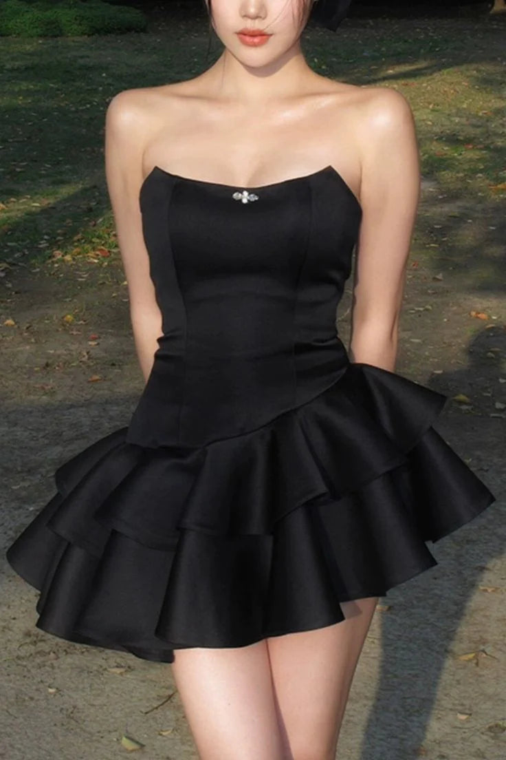 Front view of a woman in a chic black strapless short prom dress.