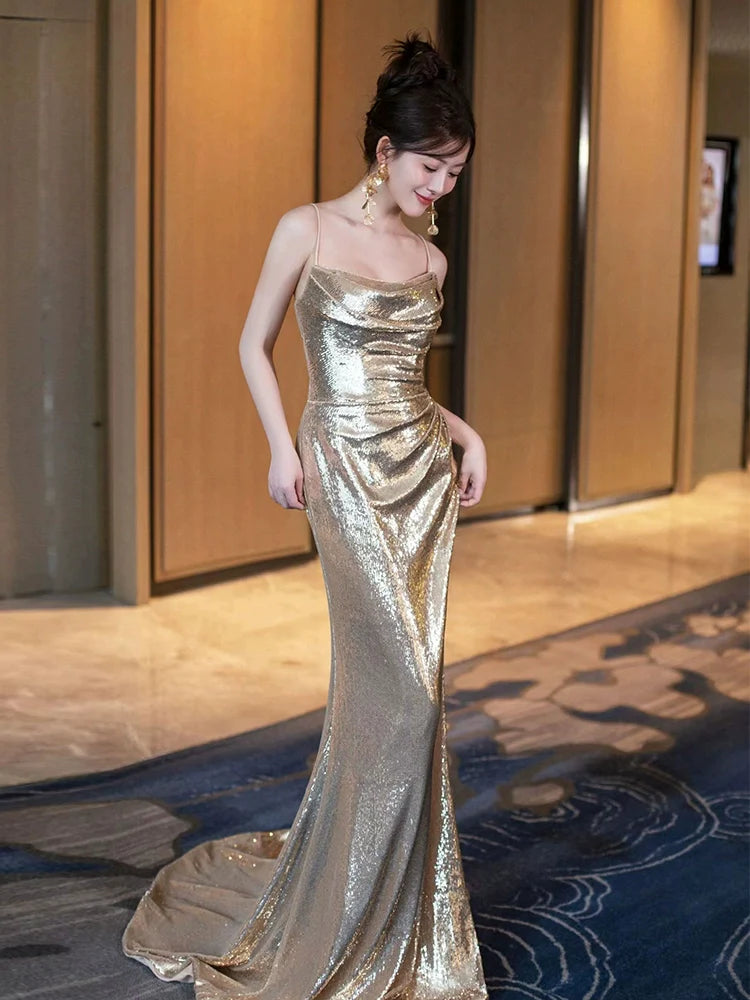 Side profile of a woman in a gold sequin mermaid gown, highlighting the elegant silhouette.