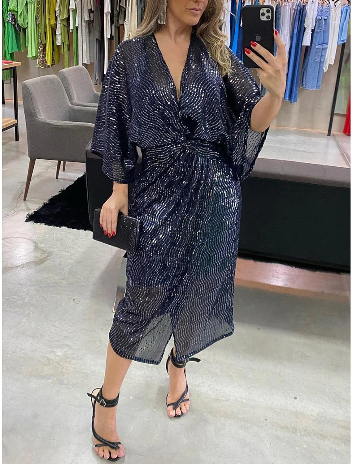Woman wearing a sparkling sequin V-neck 3/4 sleeve party dress.