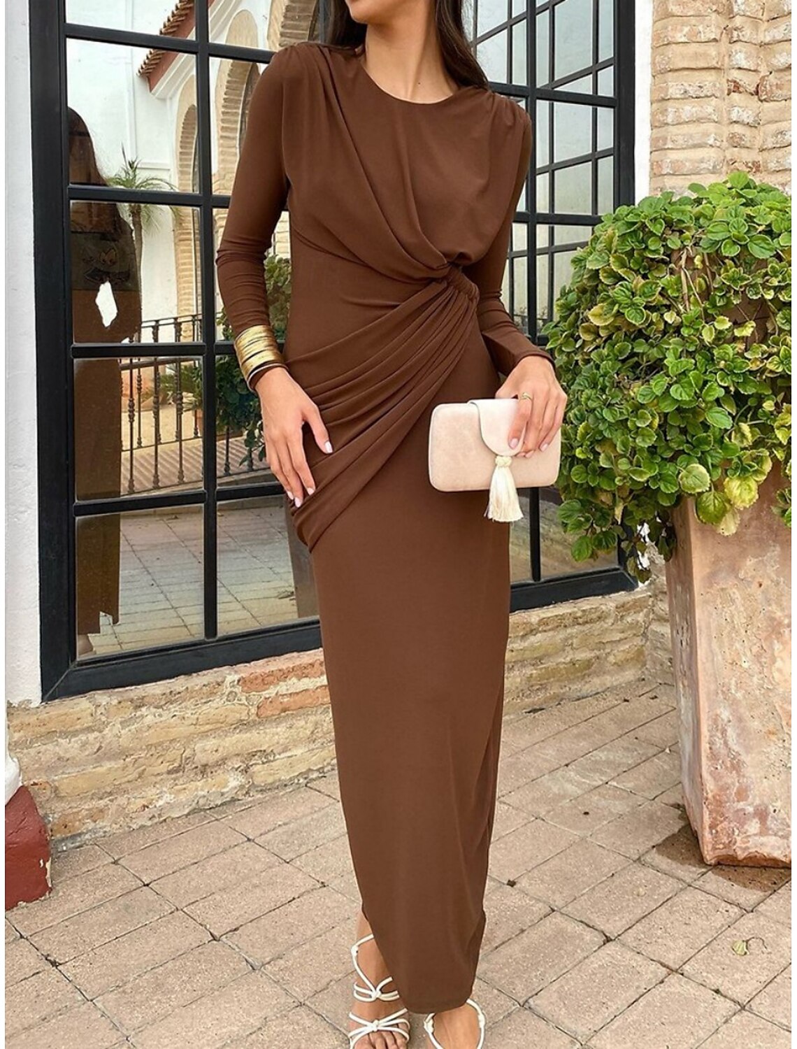 Woman posing elegantly in a brown long sleeve bodycon maxi dress.
