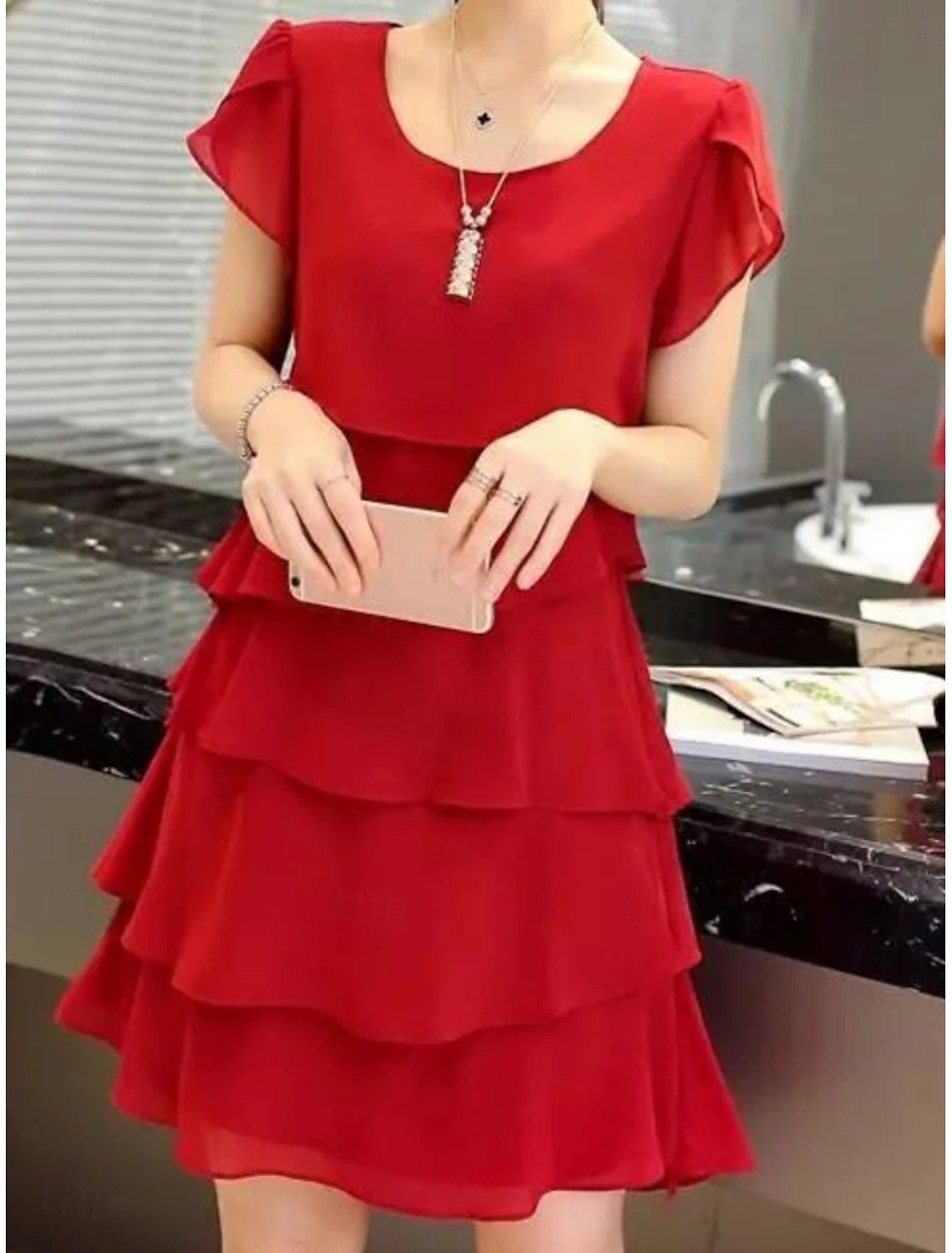 Model in a graphic mini dress, showcasing the full silhouette.
