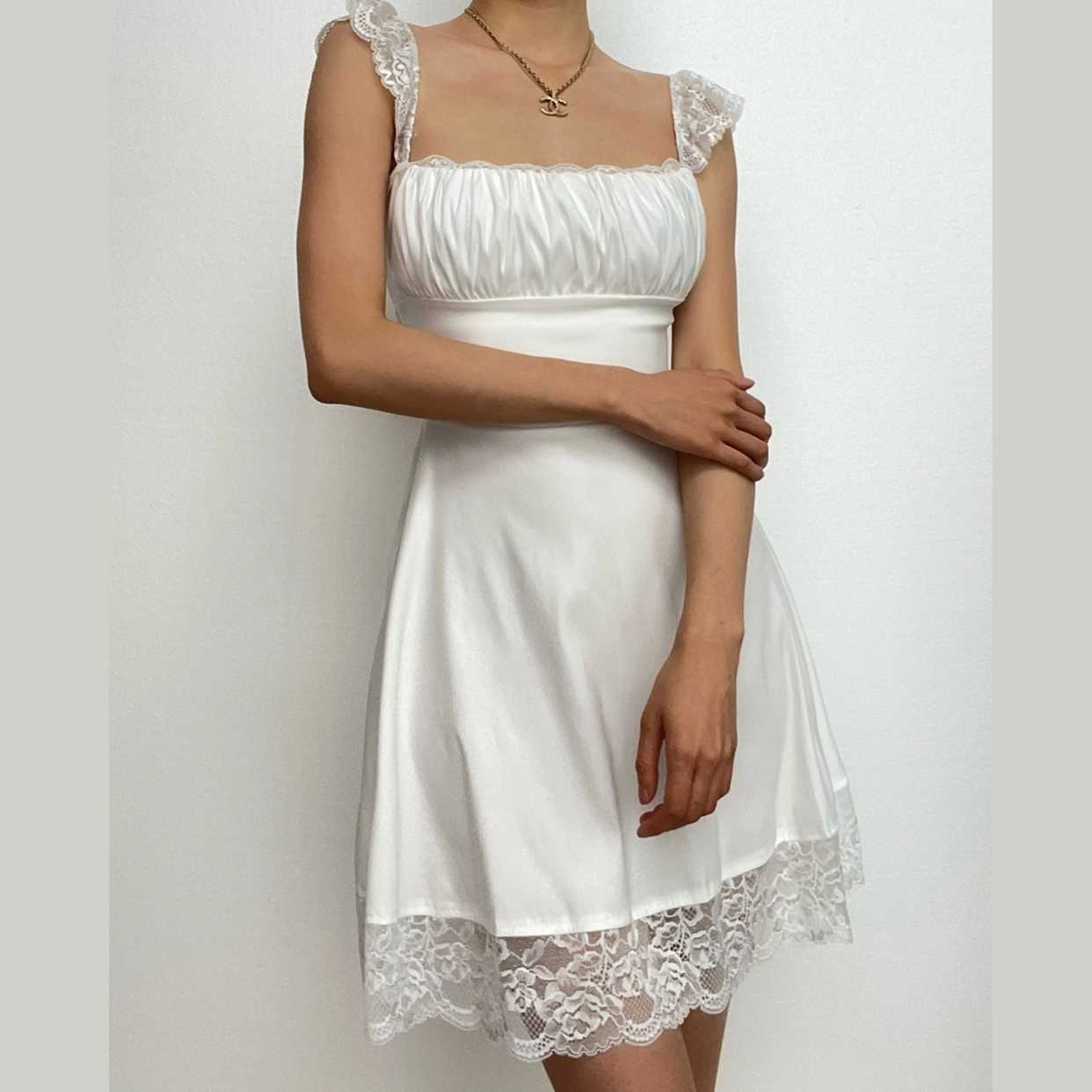 Model wearing a white A-line square neck cap sleeve ruched lace short homecoming dress, front view.