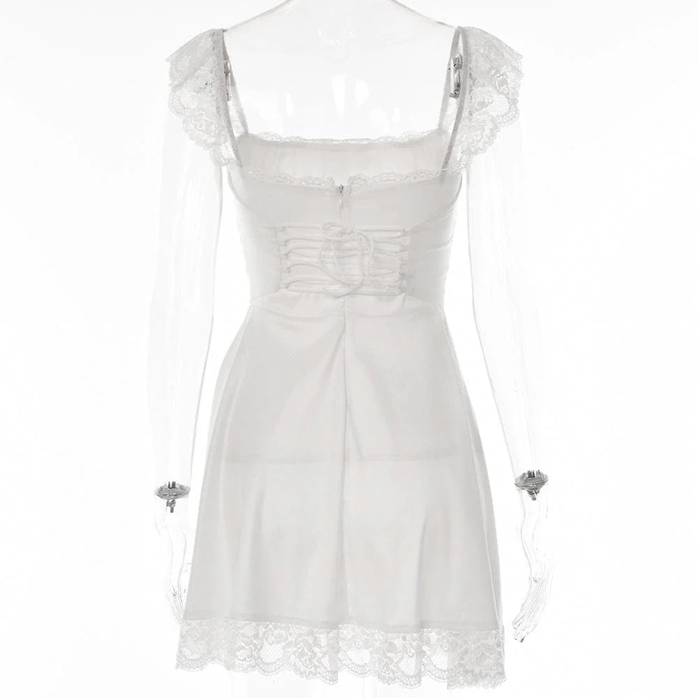 Detail of the ruched bodice and lace trim on the white A-line dress.