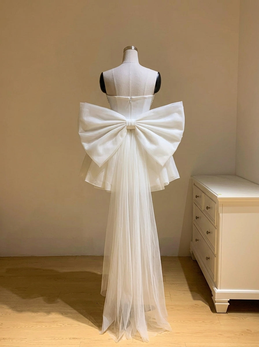 Close-up of the pearl-beaded corset and strapless neckline of the white mini dress.