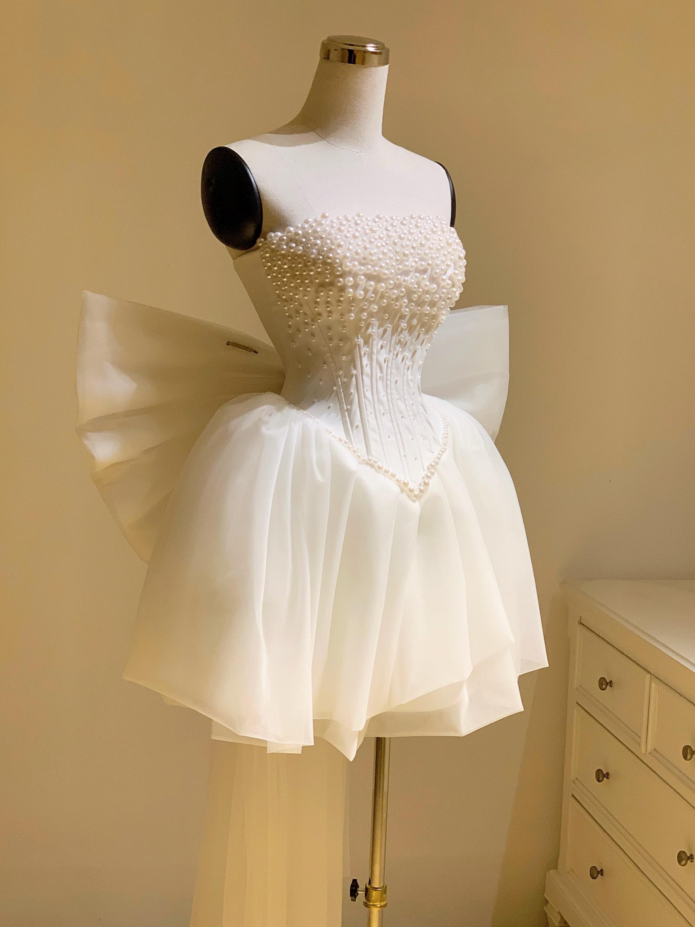 Side view of the white strapless A-line mini dress with tiered skirt.