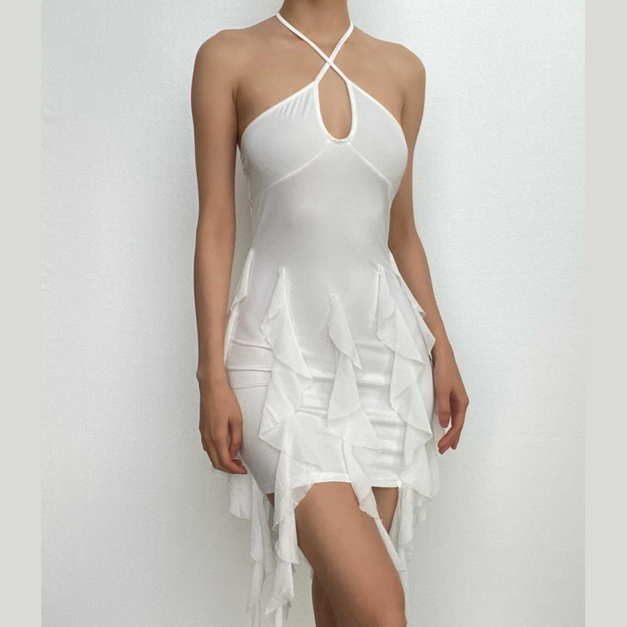 Woman wearing a white halter ruffled bodycon mini homecoming dress, front view.
