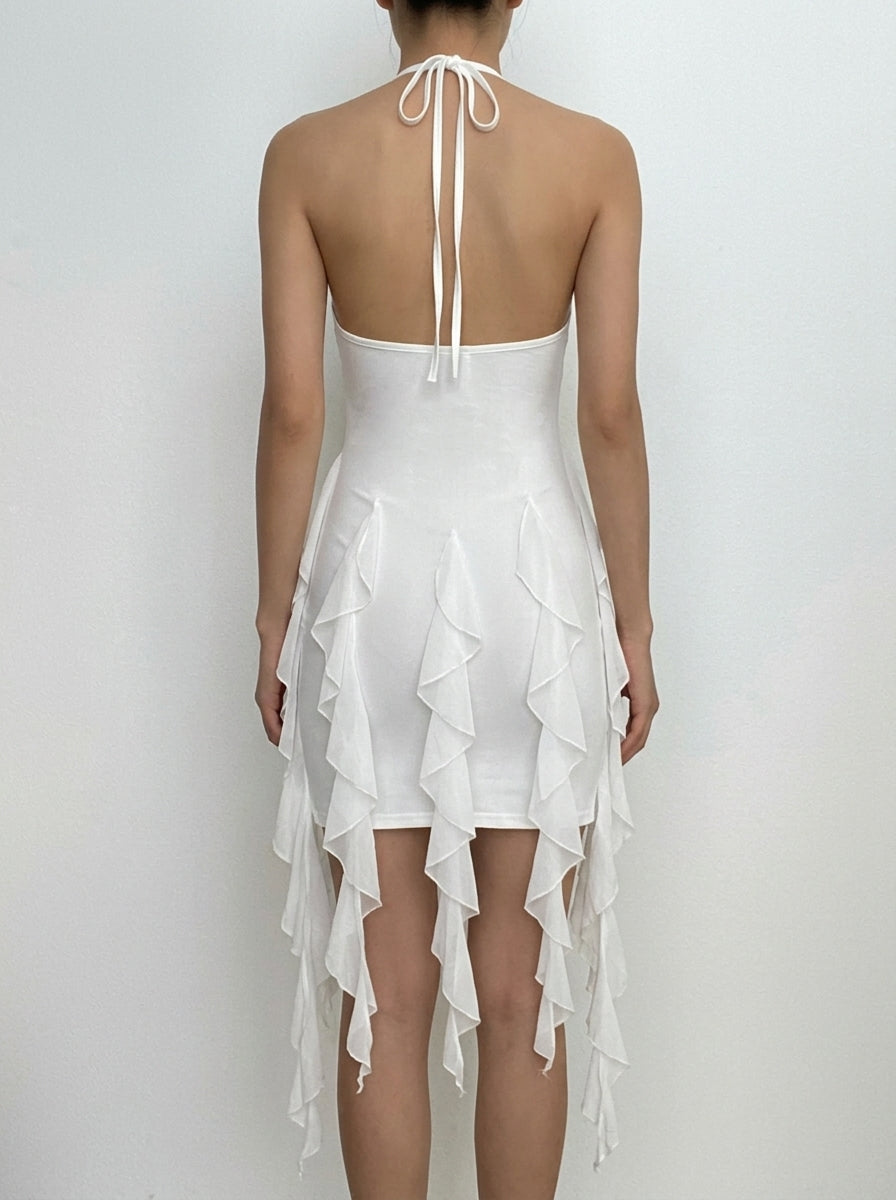 Side view of a woman in a white halter ruffled bodycon mini dress, highlighting the silhouette.