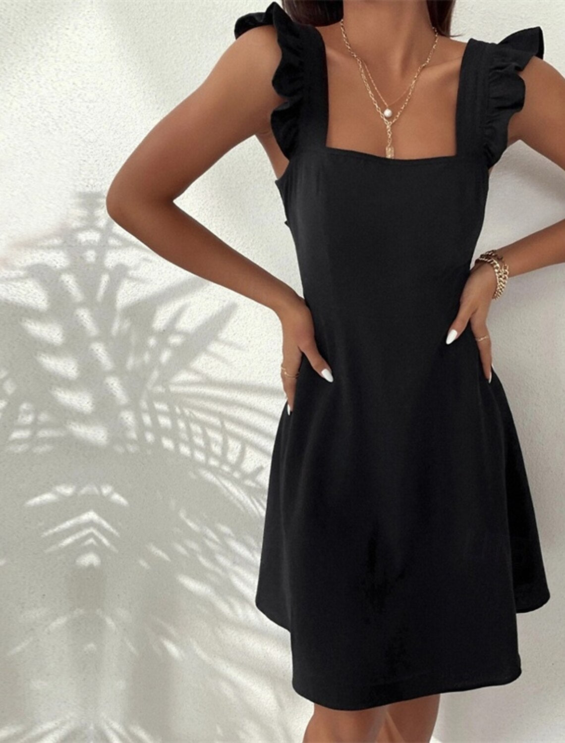 Side profile of a woman in a plain square neck butterfly sleeve summer dress.
